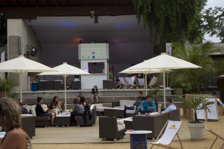 Als „Beachbar“ war der Pavillon in den Seeanlagen ursprünglich nicht konzipiert. Er erinnert vielmehr daran, dass die Bregenzer durch den Bau der Bahnstrecke seit 1872 vom Seeufer getrennt lebten. Deshalb schlug 1880 die Geburtsstunde der Seeanlagen. 1887 zierte ein Pavillon dann die erste Landesausstellung. Er blieb als einziger übrig, 1949 wurde das baufällig gewordene Stück durch einen Pavillon von der Hand des Architekten Claus Ströbele ersetzt. Am 21. Juli wurde er eröffnet, gerade rechtzeitig zur Festspielzeit. Foto: VN/Paulitsch, Matt