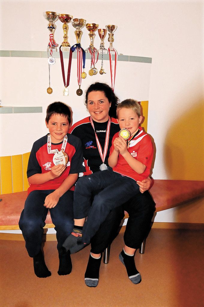 Andrea Tagwerker mit ihren Söhnen Marcel (l.) und Lukas (r.), die stolz ihre vielen Medaillen zeigen. Foto: akp
