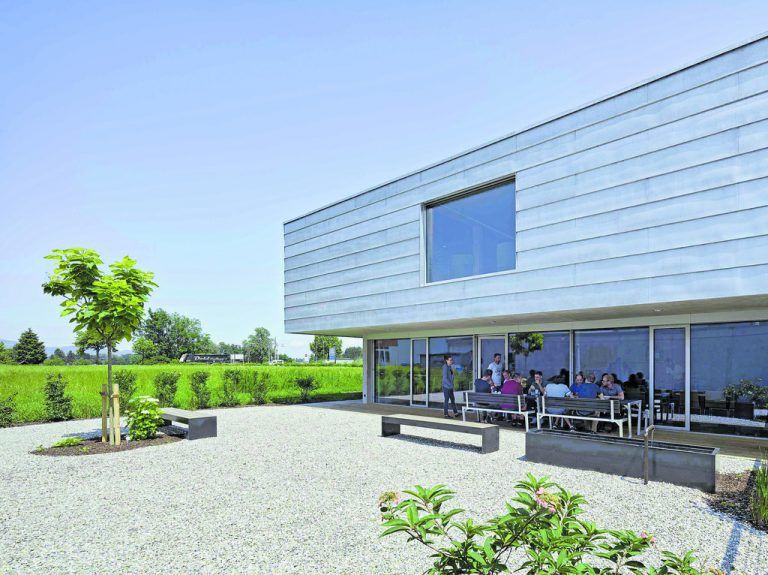 Im Erdgeschoß ist der große Mitarbeiterbereich in Richtung Süden raumhoch verglast. Sich öffnend zu einer großzügig dimensionierten holzbeplankten Terrasse bzw. einem bekiesten Garten.