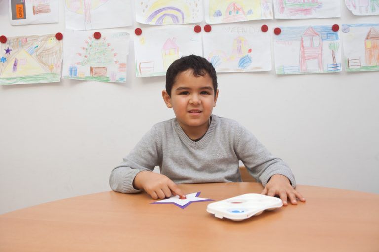 Seyhan gibt dem Rentier mit zwei Fingerabdrücken Kopf und Körper und malt den Rest dazu.