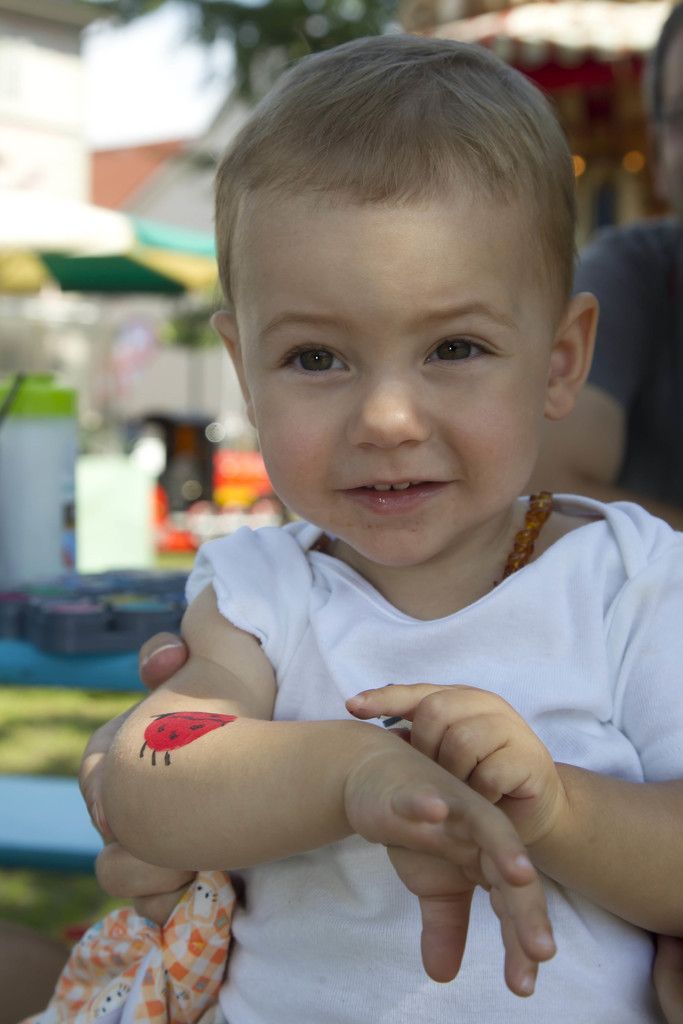 Stolz zeigt Timmi den Marienkäfer aus Farbe auf seinem Arm.