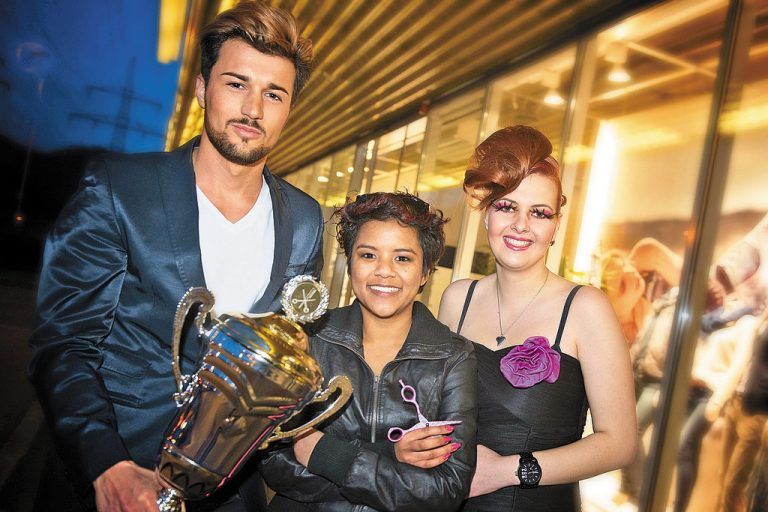 Strahlende Siegerin: Janine Lässer (Mitte) mit ihren Frisurenmodellen und Pokal. Foto: Stiplovsek