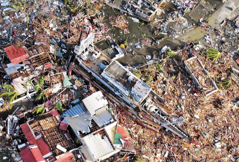 Was der Taifun „Haiyan“ mit Windspitzen von 380 km/h angerichtet hat: Ein Schiff steht in einer verwüsteten Siedlung von Tacloban. Foto: EPA