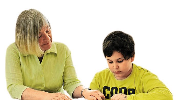 An Mathe-, Englisch- und Deutschtischen helfen Ehrenamtliche den Kindern bei den Hausaufgaben. Foto: Caritas
