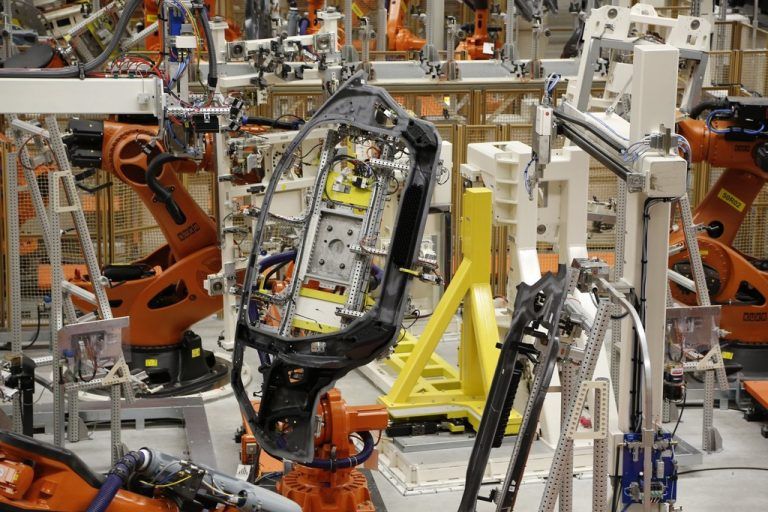 Einzelteile werden von Roboterhand produziert.