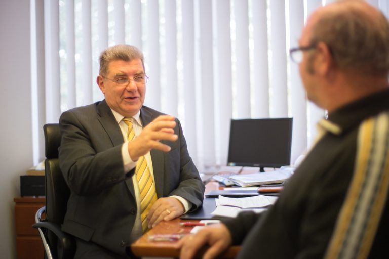 Erich De Gaspari in seinem Büro, im Gespräch mit einem nach Rat suchenenden Pensionisten. Foto: VN/Hartinger