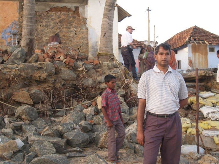 Georg Thaniyath im Jahr 2005 vor den zerstörten Häusern ...