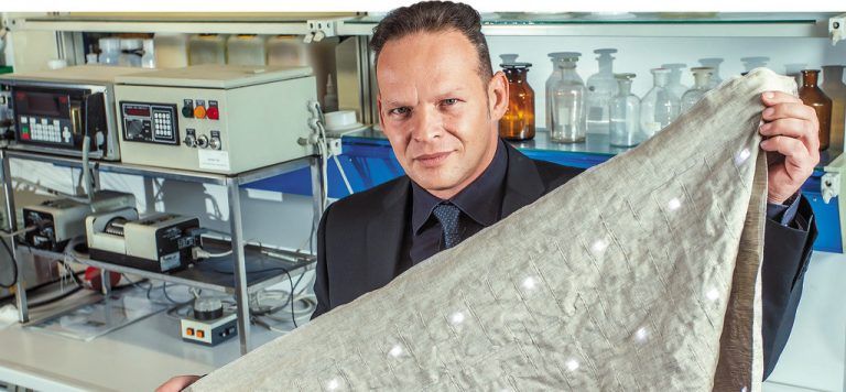 Günter Grabher bei V-Trion im Labor mit einem technischen Textil aus dem Hause der Grabher Group, das schließlich ein Sternenhimmel für ein Modell eines deutschen Autobauers werden soll. Fotos: VN/Steurer