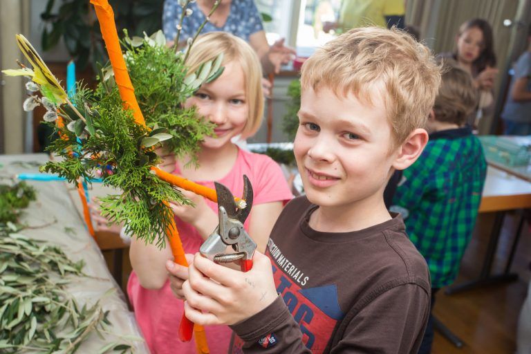 Noch ein Schnitt, und Markus (8) hat seinen Palmbuschen fertig. Emma Jekatharina (9) hält das Vorbild in Händen.