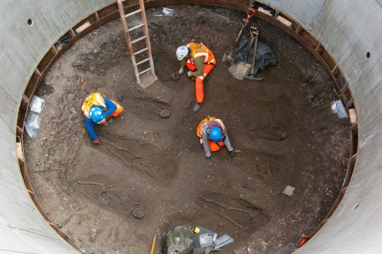 Archaeologists work on unearthed skeletons in the Farringdon area of London in this undated handout photograph released March 15, 2013. Archaeologists said on Friday they had found a graveyard during excavations for a rail project in London which might hold the remains of some 50,000 people killed by the 