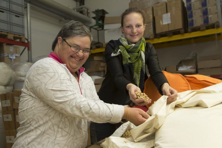 Der Parade-Großhändler in Sachen Nachhaltigkeit, Stefan Grabher (Mitte und rechts außen), mit Paptex-Mitarbeitern und Lebenshilfe-Team beim Füllen von gesunden Schlafkissen mit Hirse, Dinkel und Zirbe. FotoS: VN/Paulitsch