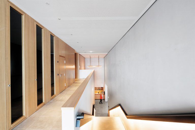 Eine einläufige Treppe führt vom Eingangsbereich hinab in das Foyer direkt auf die Information und die Kassa zu.