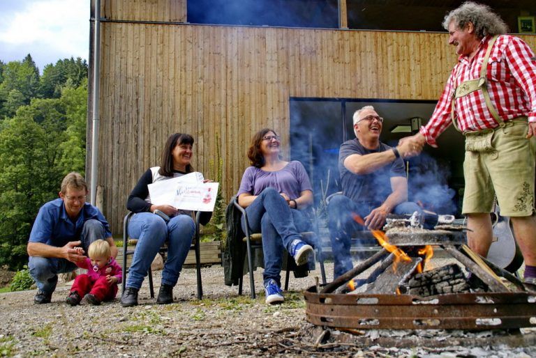 Reinhold Fromm begrüßt Airbnb-Gäste aus Brasilien vor seiner Ferienhütte in Hittisau. Foto: Yvonne Bechter