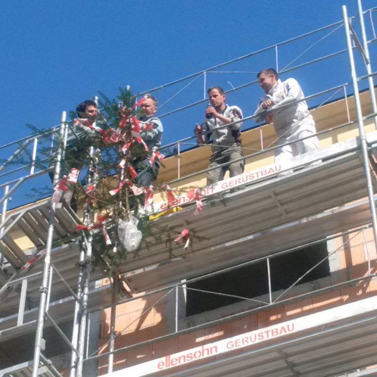 Wälderbau-Mitarbeiter beim Aufziehen des Firstbaums. Foto: Rhomberg Bau