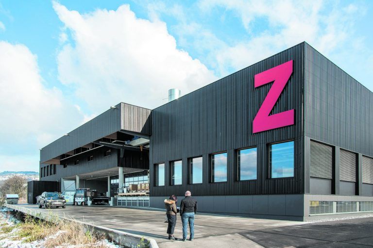 Alle vier Fassaden von z-werkzeugbau sind mit dunkelbraun eloxiertem Trapezlochblech verkleidet. Alle Fenster sind gleich groß, wenn auch unterschiedlich angeordnet, die Lüftungsflügel sind hinter den vertikalen Lisenen versteckt.