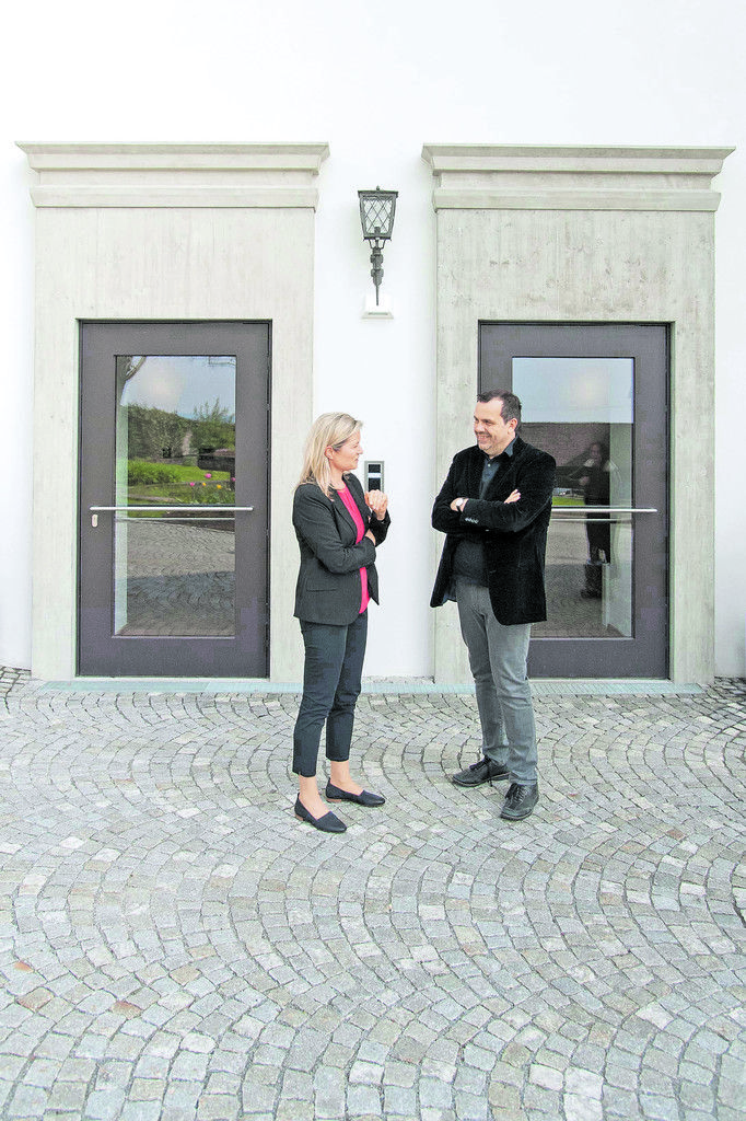 Architekt Stefan Marte mit Manuela Partel, der Leiterin des Seminarhotels, vor zwei Türen, deren Umrahmungen als reizvolles Zitat der originalen aus Sandstein nun aus Sichtbeton gebaut sind.