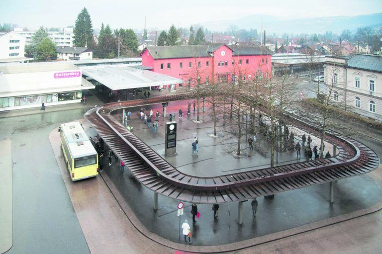 Blick vom neuen vierten Obergeschoß auf den Bahnhofplatz, der täglich von Tausenden Menschen frequentierten Drehscheibe des öffentlichen Verkehrs in Dornbirn. Umstellt von Gebäuden in den unterschiedlichsten Architektursprachen.