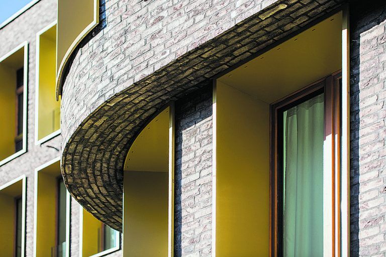 Das Wechselspiel von mit Klinker verkleideten massiven Stützen und in gelbe Alu-Kästen innenbündig eingesetzte Fenster geben dem „Seegarten“ ein unverwechselbares „Gesicht“.