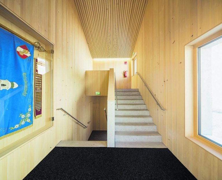 Der Blickfang Standartenvitrine ziert den bergseitigen Zugang zu den Schulungsräumen – Treppauf zur Bergrettung, treppab zur Feuerwehr.