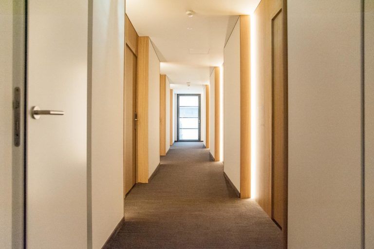Die Wände des Gangs sind die Außenseite der Boxen. In den Wand-vorsprüngen laufen alle Leitungen.