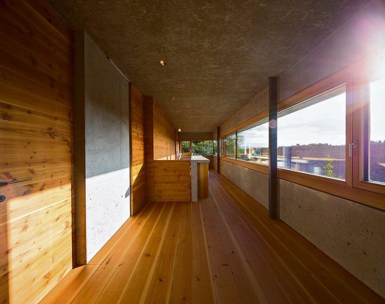 Ein durchgehendes,über eine Ecke gezogenes Fensterband bringt vielLicht ins Obergeschoß, das ebenfalls von den Materialien Holz und Beton dominiert wird. Auf Sonnenschutz wird derzeit noch verzichtet.