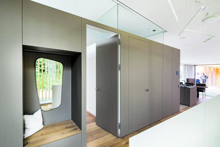 Eine Box mit Oberlichten wurde in des große, loftartige Wohn- und Esszimmer hineingestellt. Nach außen ist sie eine Garderobe, innen befinden sich Schlaf- und Badezimmer.