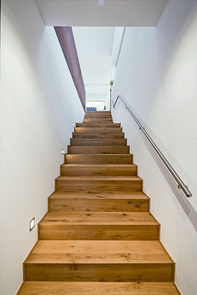 Eine schöne, lange, einläufige Treppe aus geölter Eiche führt von der Garderobe in die Wohnebene hinauf.