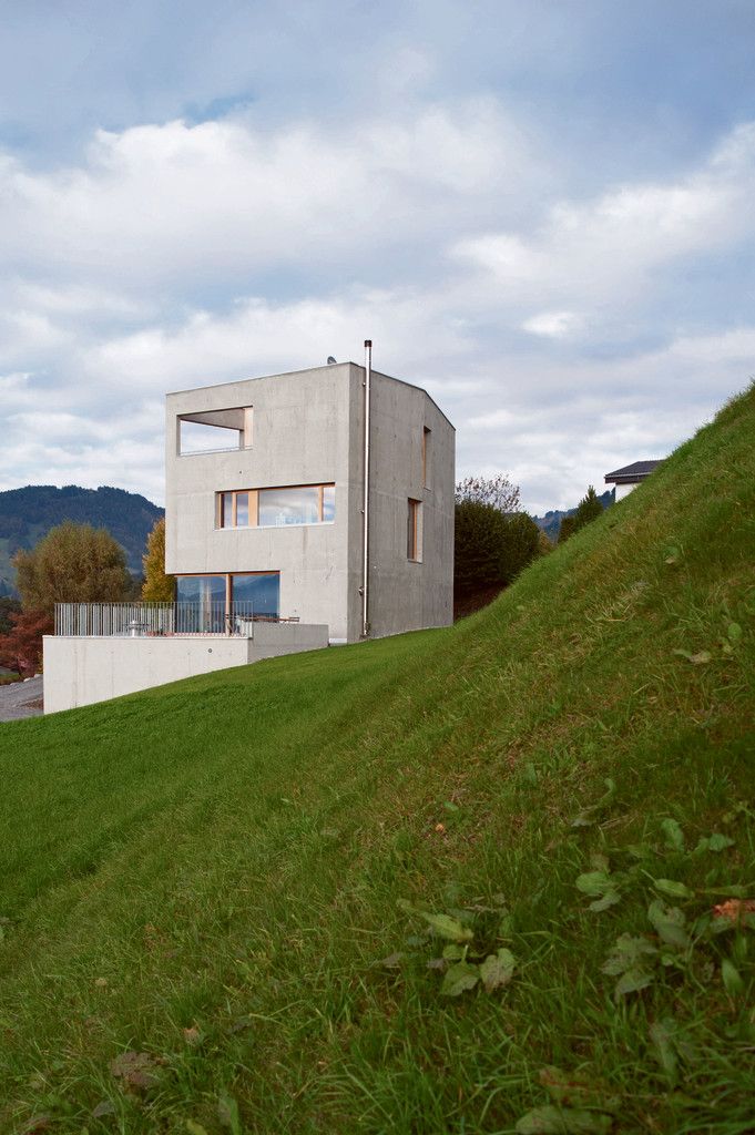 Hanglage. Das Gebäude schneidet sich in den Hang ein. Die Höhe des Gebäudes ist in Auseinandersetzung mit der Topografie und der Kubatur der umliegenden Gebäude entstanden.