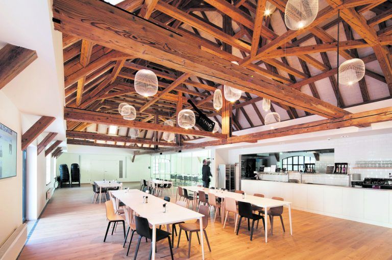 HENN’s Kitchen, das Betriebs-restaurant, ist Treffpunkt und versorgt die Mitarbeiterinnen und Mitarbeiter mit Frühstück und Mittag-essen und fördert eine gute Pausenkultur.