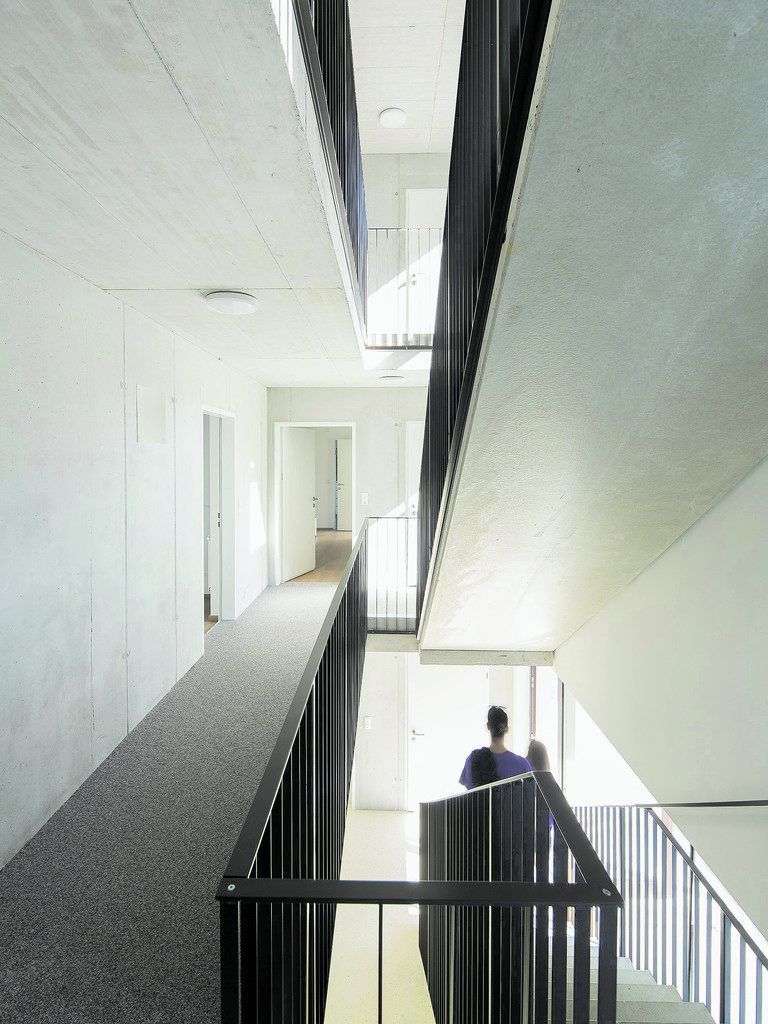In den Stiegenhäusern dominiert Sichtbeton. Die Eingangstüren zu den Wohnungen sind weiß, die Stiegen haben schlichte Staketengeländer aus dunkel eloxiertem Metall, die Böden einen Teppichbelag.