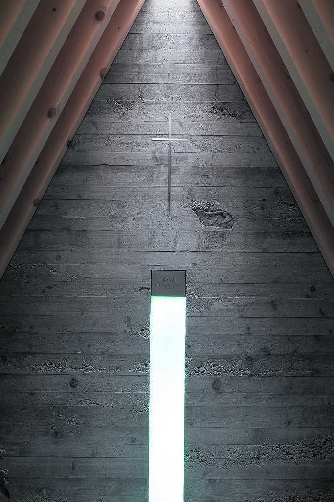 Kein Blick nach außen stört die Konzentration. Licht durch blaues Glas, darüber das feine Kreuz vom Schlosser, Licht von oben.