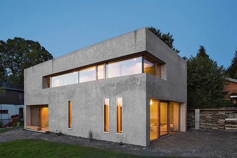 Klare Formen dominieren das Haus Bernhardt. Plastisch strukturiert werden die Fassaden durch wenige, aber markant innen bzw. außen bündig gesetzte Fenster und Türen. Sie sind im Eingangsbereich und zum Garten hin raumhoch.