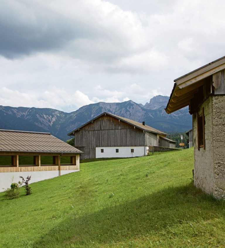 Rückseitig ist das Dorfhaus in den leicht abfallenden Hang geschoben. Wo das Haus diesen berührt, ist es aus Stahlbeton gebaut, genauso wie die traditionellen Gebäude der Umgebung dies vorzeigen.