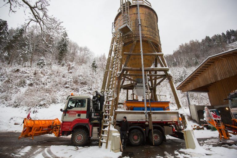 Salz aus dem Silo ausfassen. Auf den Straßen ist es winterlich.