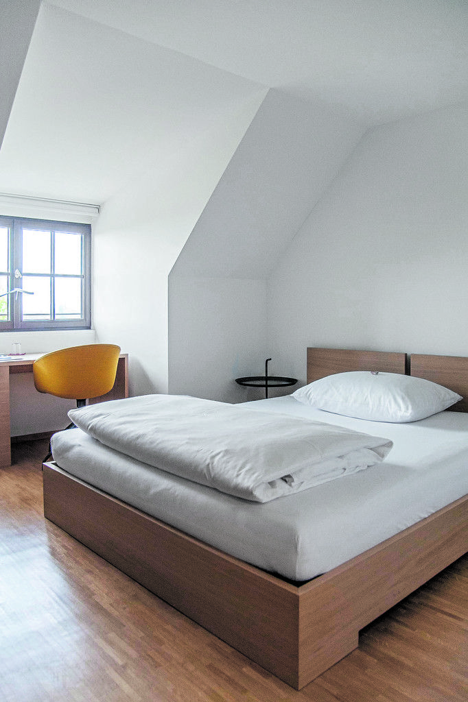Schlicht ist auch die Einrichtung der 31 Gästezimmer. Platz durfte hier nicht verschwendet werden, weshalb die Architekten das Bad raffiniert hinter einer Schrankwand verschwinden lassen.