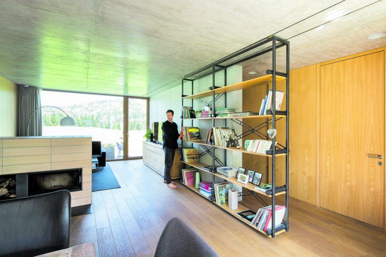 Sebastian Brandners Leidenschaft ist nicht nur die Architektur, sondern auch das Design. Von ihm entworfen ist etwa das Regal, das auf in die Sichtbetondecke eingelassenen Stahlschienen läuft, um auf diese Weise zum raffinierten Trennelement zwischen„öffentlichem“ und „privatem“ Raum zu werden.