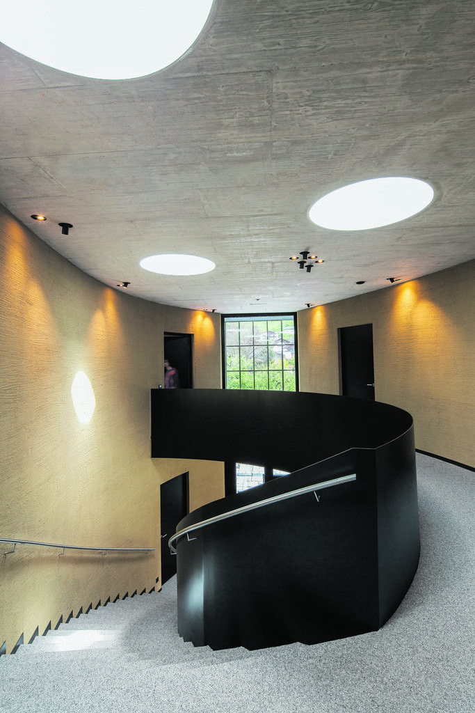 Selbsterklärend führt die Treppe in den ersten Stock, wo die um einen linsenförmigen Luftraum geschwungene Galerie als gemeinschaftliche Kommunikationszone die Büros erschließt.
