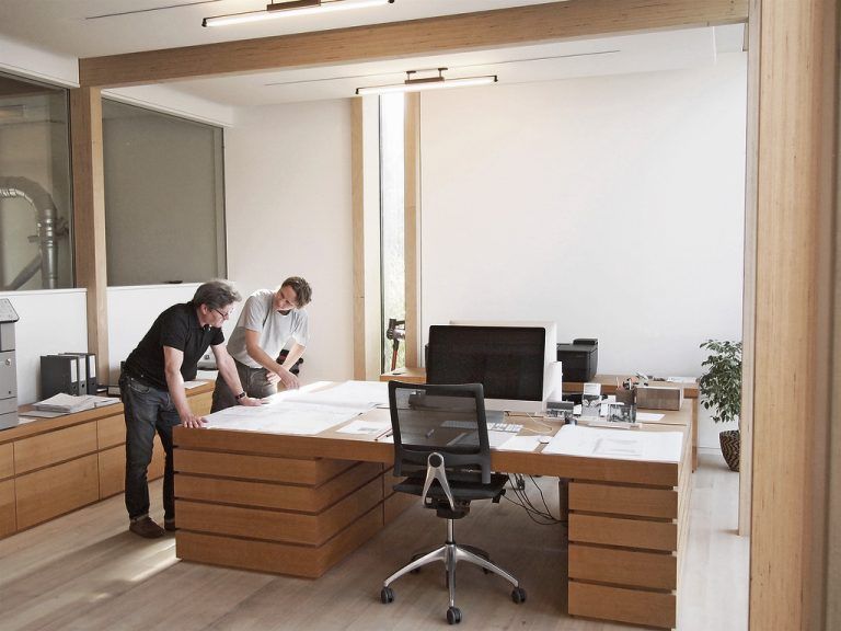 Senior und Junior: Anton und Thomas Mohr über Plänen im freundlich hellen Büro, das zugleich als Empfangsraum für Kunden und Gäste funktioniert.
