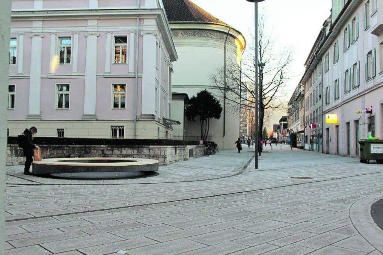 Vom Rondeau lässt sich das Geschehen am Platz und in den angrenzenden Gassen gut beobachten. Eine Basis aus dunklem Beton veran-kert es im Boden. Die Sitzfläche besteht aus Kiefernholz, das für höhere Robust-heit mit Essigsäure behandelt wurde.