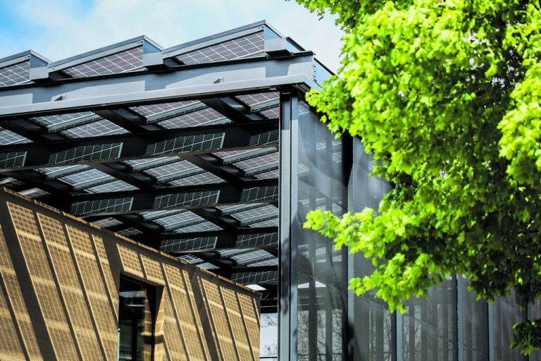 Was dieses Gebäude einmalig macht, ist sein weit auskragendes Dach mit 288 semitransparenten Glasplatten, von denen einige als Photovoltaik-Elemente ausgebildet sind. Außerdem bilden im ersten Stock umlaufende, semitransparente Aluminiumpaneele eine geschützte Schicht um das Haus.