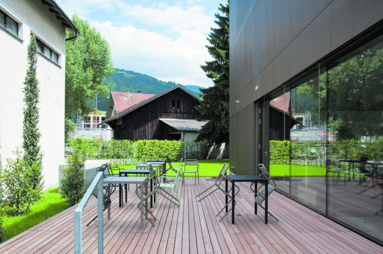 Zeitreise Auf der Rückseite ergänzt eine Terrasse den Frühstücksraum. Hier mischen sich unvermittelt Bauten verschiedenster Stile und Nutzungen.