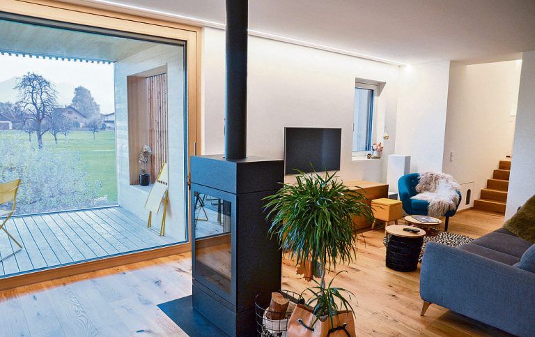 Zentrum des Wohnraums ist ein großer schwarzer Ofen, der mit Holz befeuert wird. Er sorgt nicht nur für wohliges Knistern, sondern ist auch so etwas wie ein Raumteiler zwischen der gemütlichen Sitzecke und dem Esstisch.
