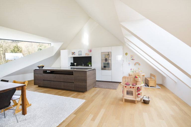 Zur einen Seite wird gekocht und gegessen. Die markanten Dacheinschnitte lassen auch hier die Architektur dominieren, in der Möbel mitunter klein und verloren wirken können.