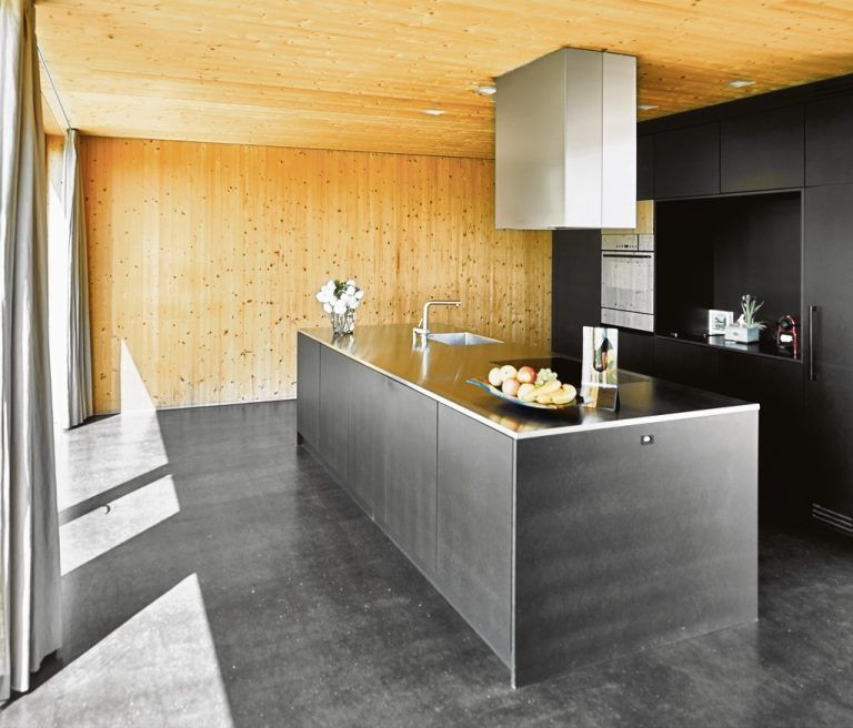 Die Küche aus schwarz eingefärbter mitteldichter Holzfaserplatte (MDF) ergibt einen starken Kontrast zum hellen Holz.