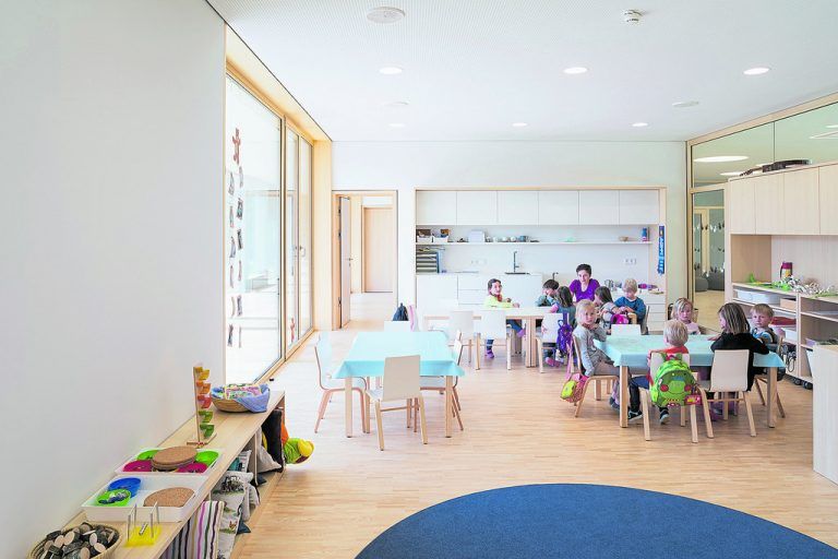 In den Gruppenräumen wird die Balance zwischen Intimität und Offenheit geschickt gewahrt. Holz, Glas und die Farbe Weiß dominieren, Farbe bringen die Kinder ins Haus.
