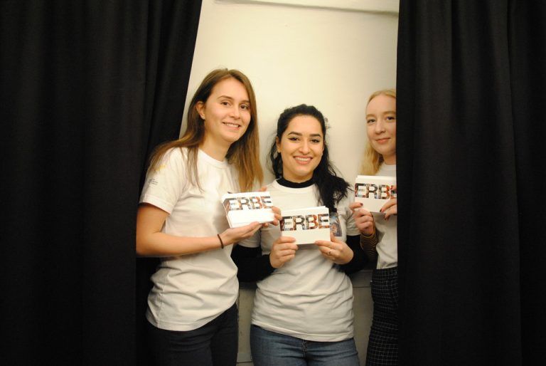Sophie, Hosna und Emelie präsentieren Werbematerialien für das gemeinsame Projekt.