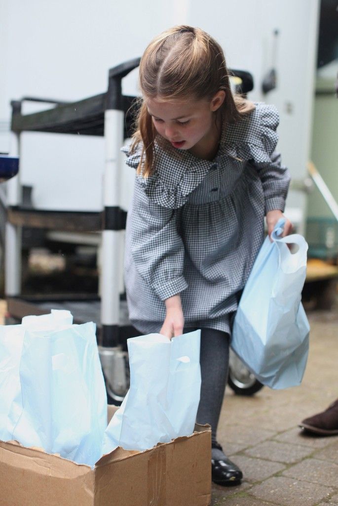 Die kleine Prinzessin hilft beim Einpacken von Lebensmittelpaketen für Bedürftige. AFP