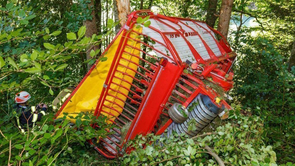Heu-Schlepper rollt Hang hinunter und kracht in Wald