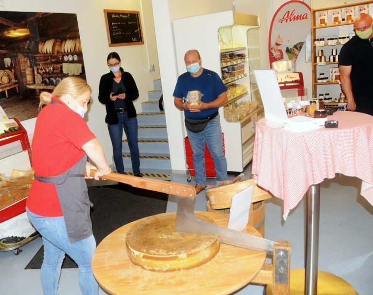 Aida schneidet den Alpkäselaib von der Alpe Obere in Mellau an, im Hintergrund Daniela Janner, Alma. ajk