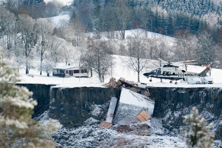 Ein Polizeihelikopter landet neben einem zerstörten Haus. AFP